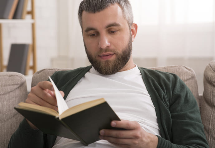 Mężczyzna czyta książkę na temat cech kapusty kiszonej.